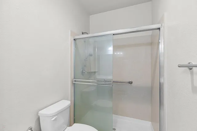 a view of swimming pool with outdoor seating and trees in the background