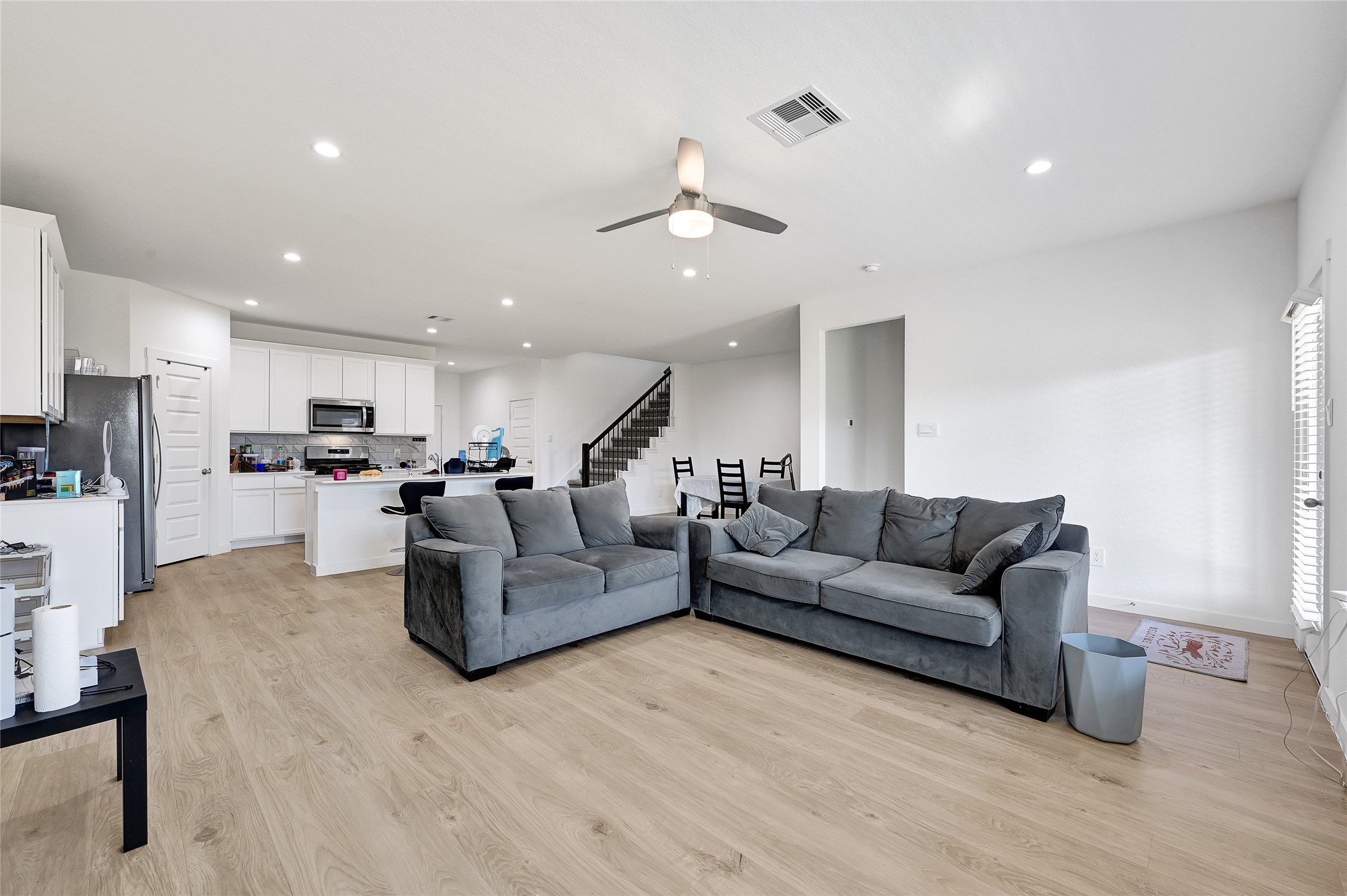 31703 Theodore Bend Drive Fulshear, TX 77441 - Photo 13 of 24 a living room with couches and kitchen view with wooden floor