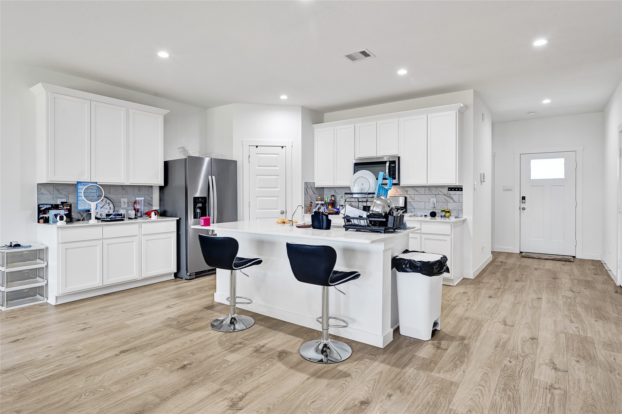 31703 Theodore Bend Drive Fulshear, TX 77441 - Photo 8 of 24 a kitchen with kitchen island white cabinets and stainless steel appliances