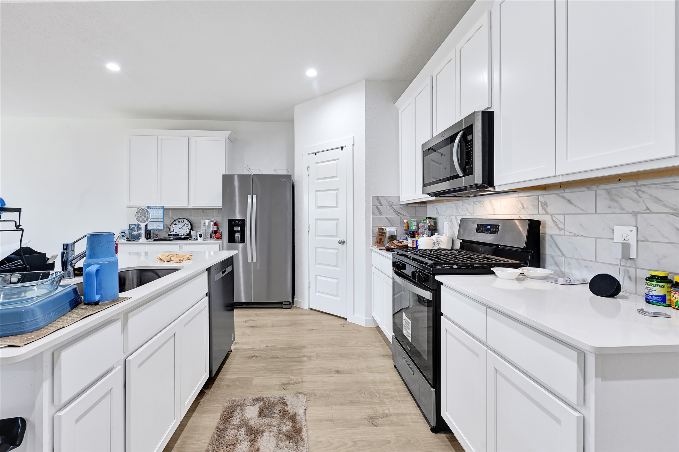 31703 Theodore Bend Drive Fulshear, TX 77441 - Photo 9 of 24 a kitchen with stainless steel appliances and white cabinets