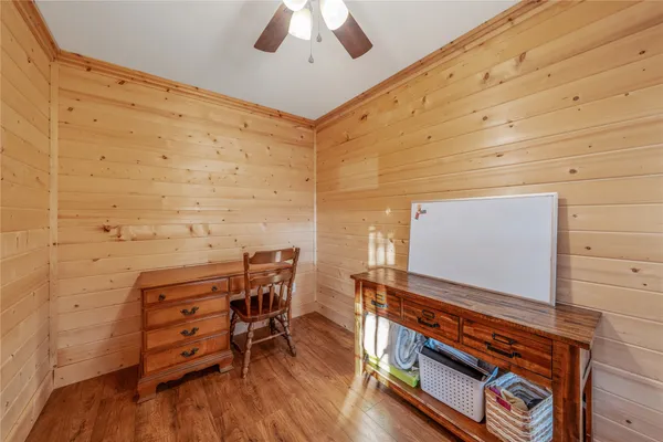 a view of a room with chairs and wooden floor