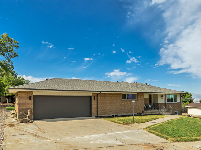 1168 East Center Street Bountiful, UT 84010 - Photo 2 of 38 Brick exterior featuring a two-car garage, concrete driveway, and covered front entry