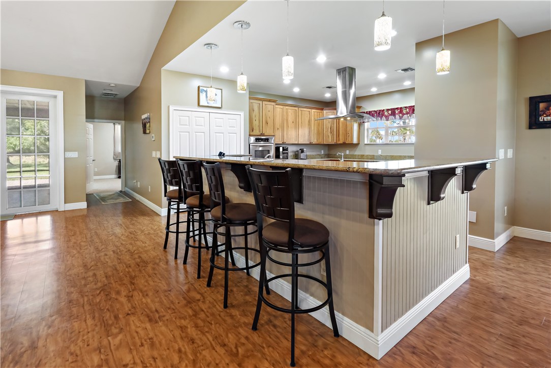 6045 21st Street Southwest Vero Beach, FL 32968 - Photo 12 of 36 a kitchen with stainless steel appliances granite countertop a table chairs sink and cabinets