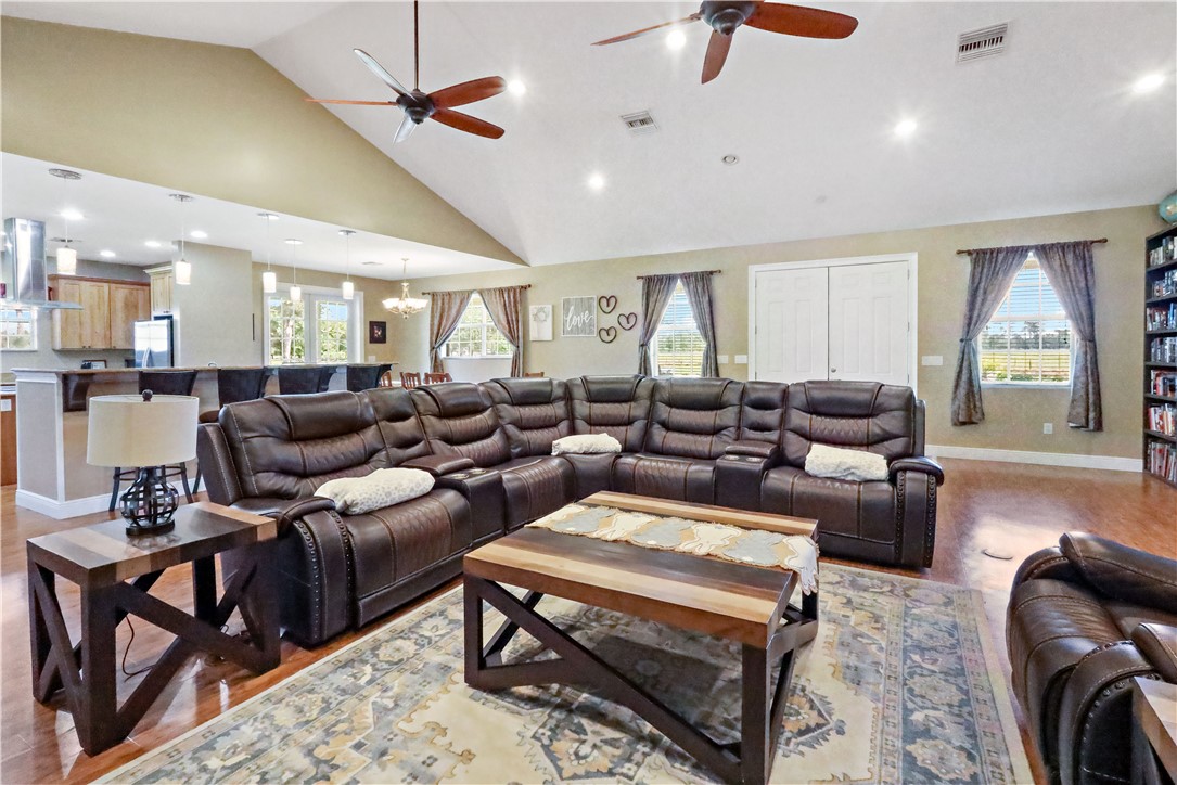 6045 21st Street Southwest Vero Beach, FL 32968 - Photo 15 of 36 a living room with furniture a ceiling fan and a rug