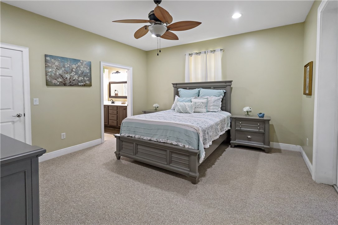 6045 21st Street Southwest Vero Beach, FL 32968 - Photo 16 of 36 a bedroom with a bed and a chandelier