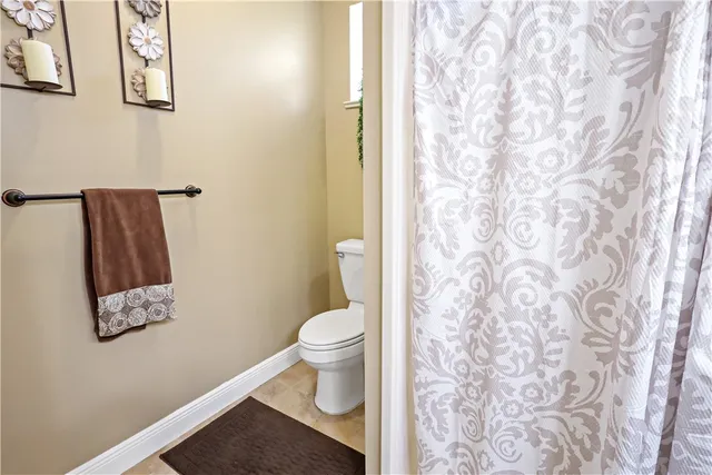 a white toilet sitting next to a shower curtain