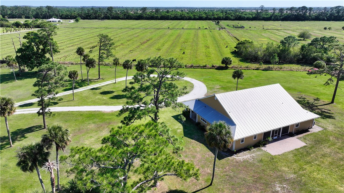 6045 21st Street Southwest Vero Beach, FL 32968 - Photo 2 of 36 a view of a lake with a yard and large trees