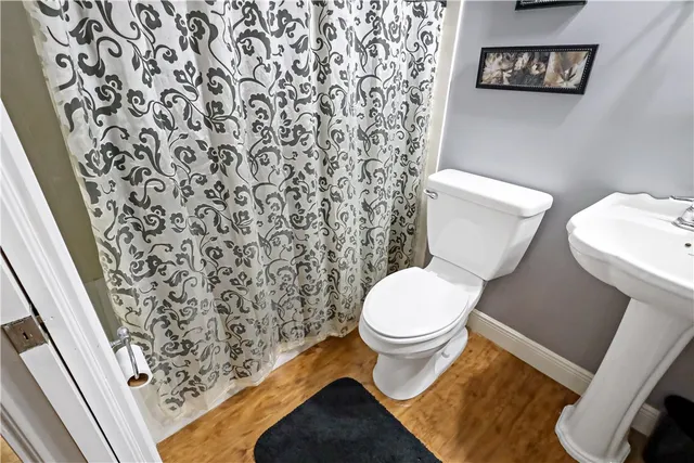 a white toilet sitting next to a shower curtain
