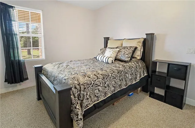 a bed sitting in a bedroom next to a window