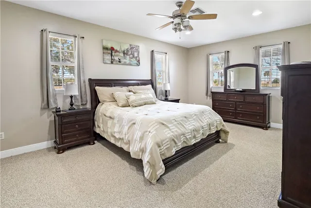 a bedroom with a bed dresser and wooden floor
