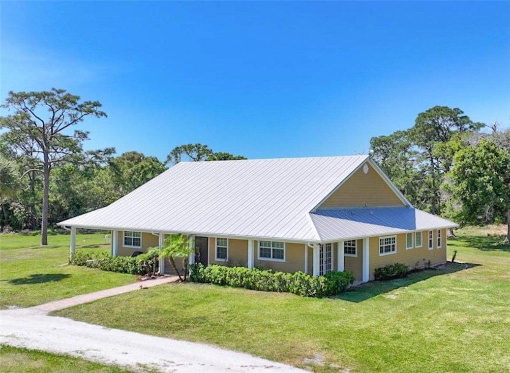 6045 21st Street Southwest Vero Beach, FL 32968 - Photo 34 of 36 a front view of a house with a yard