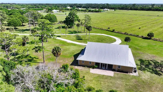 an aerial view of a house with a yard and lake view