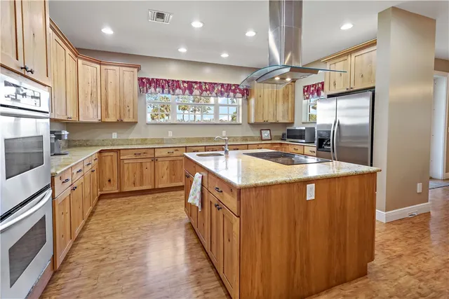 a kitchen with stainless steel appliances granite countertop a sink a stove and a refrigerator