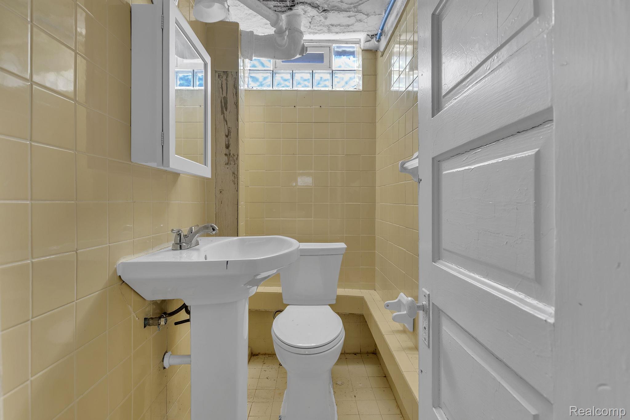 19510 Stratford Road Detroit, MI 48221 - Photo 40 of 45 Pedestal sink with chrome faucet, complemented by a medicine cabinet with mirrored doors
