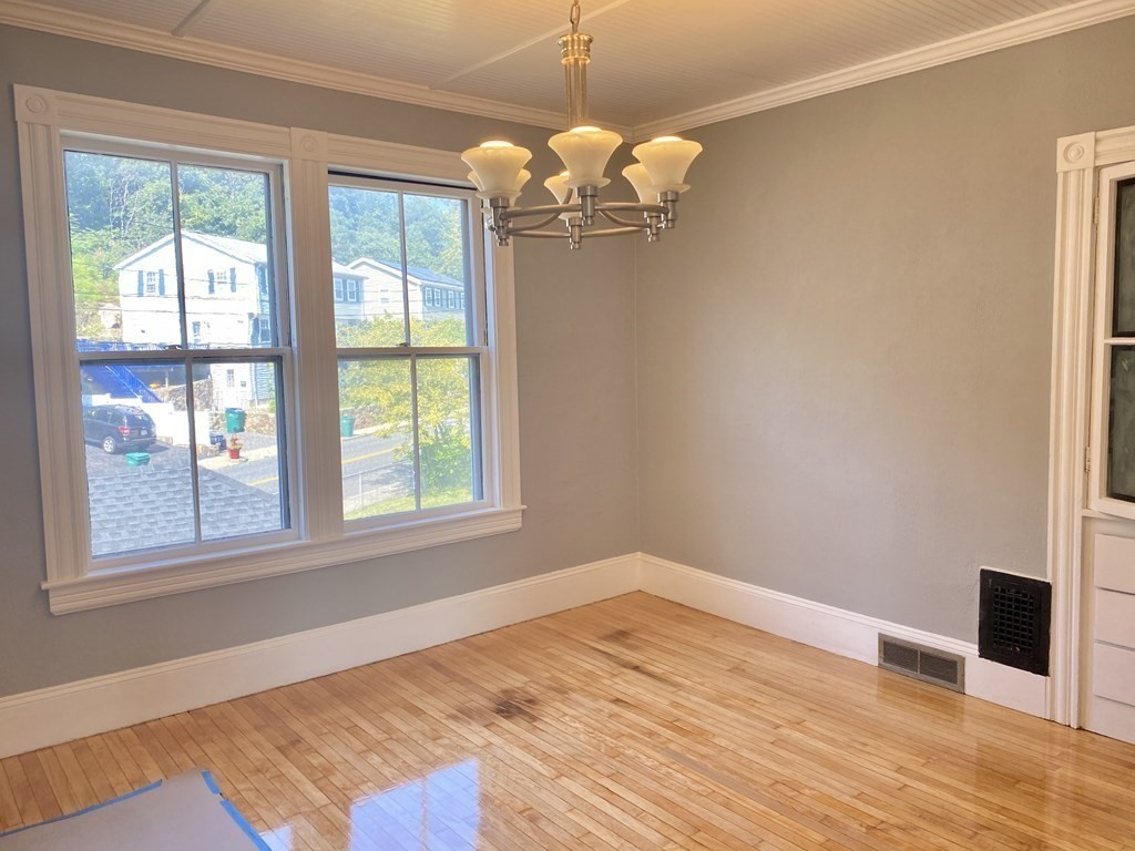 51 Walnut Street Lynn, MA 01905 - Photo 16 of 37 a view of a room with wooden floor and chandelier