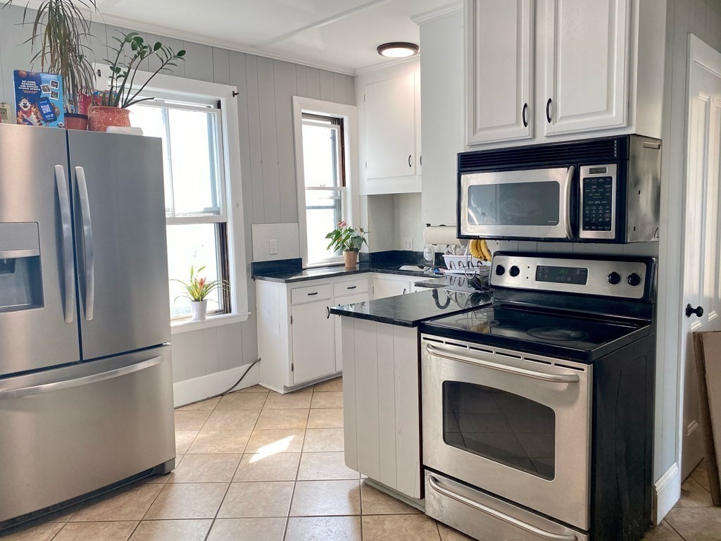 51 Walnut Street Lynn, MA 01905 - Photo 21 of 37 a kitchen with granite countertop a stove microwave and refrigerator