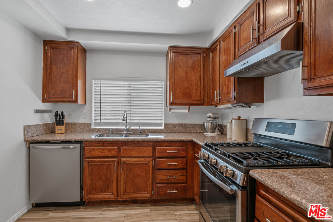 12309 Clover Road Pacoima, CA 91331 - Photo 7 of 15 a kitchen with granite countertop a sink stove and cabinets
