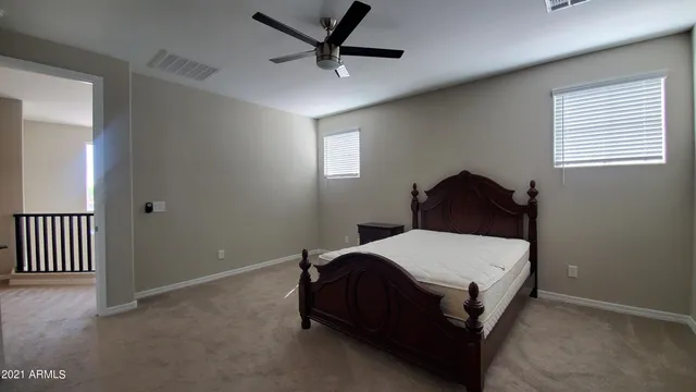 a bedroom with a bed and a ceiling fan