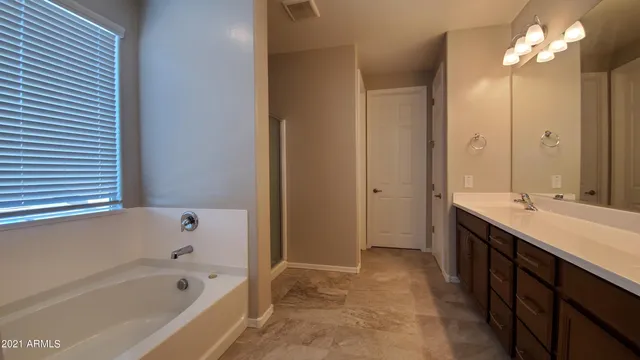 a bathroom with a bath tub sink and mirror