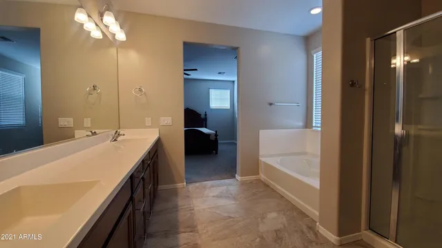 a spacious bathroom with a bathtub a sink and a mirror