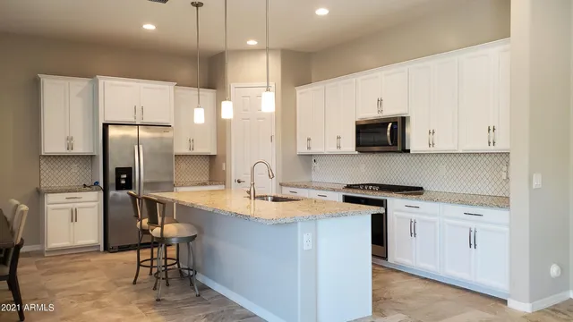 a kitchen with stainless steel appliances a stove a sink refrigerator and a microwave