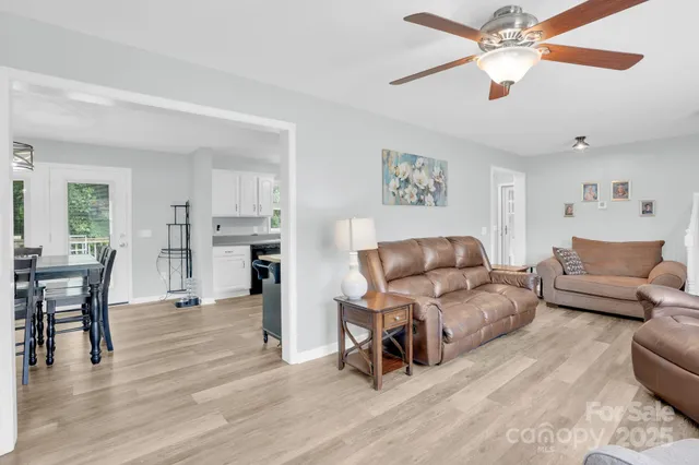 a living room with furniture and a view of kitchen