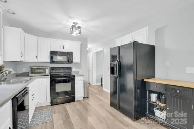 a kitchen with stainless steel appliances granite countertop a refrigerator a stove a sink and a microwave