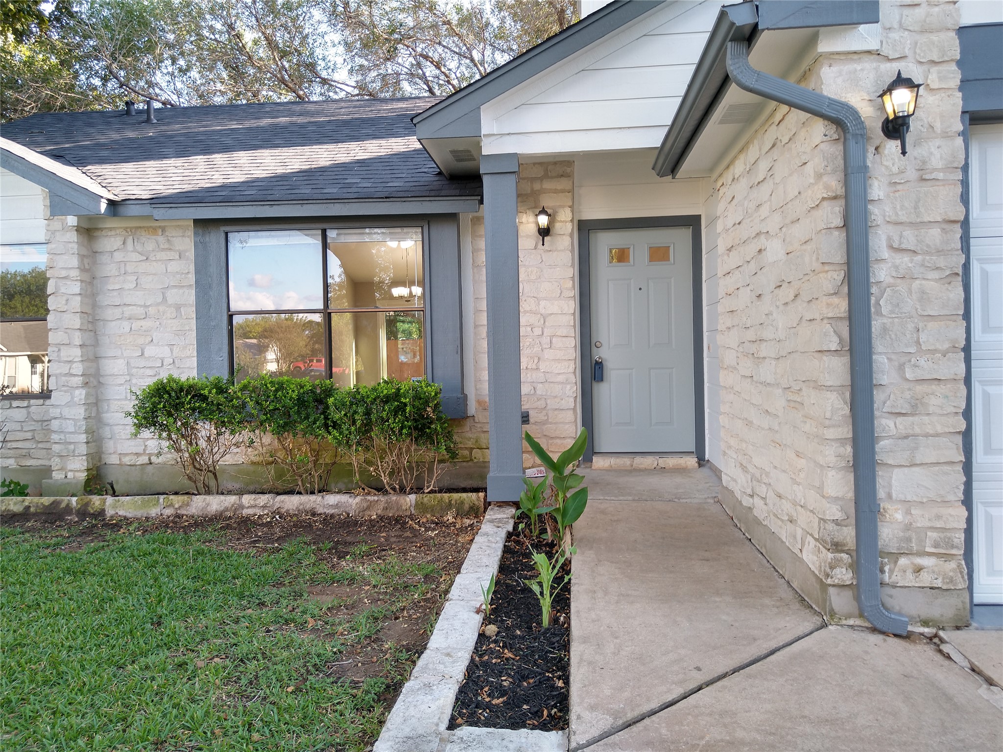 1813 Laurel Path Round Rock, TX 78664 - Photo 3 of 35 A welcoming front entrance showcases a concrete path, manicured landscaping, and a well-maintained stone facade.
