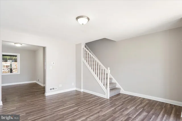 wooden floor in a hall with an entryway and a window