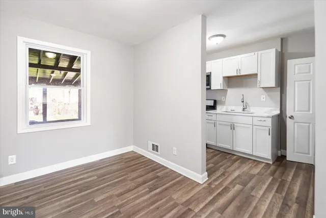 a view of a kitchen with wooden floor and a sink