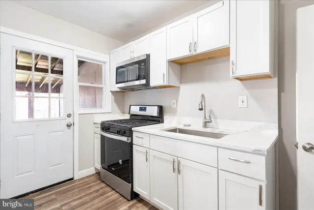 a kitchen with stainless steel appliances granite countertop a sink stove and cabinets