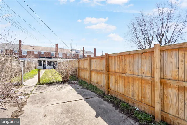 a view of a backyard with wooden fence