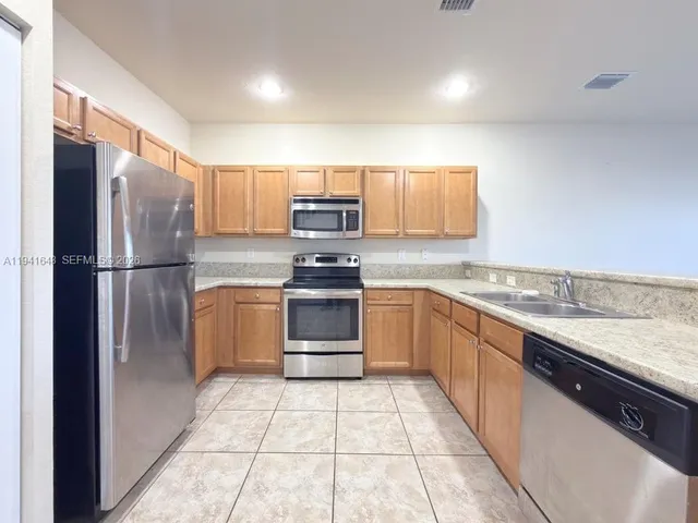 a kitchen with a refrigerator sink and microwave