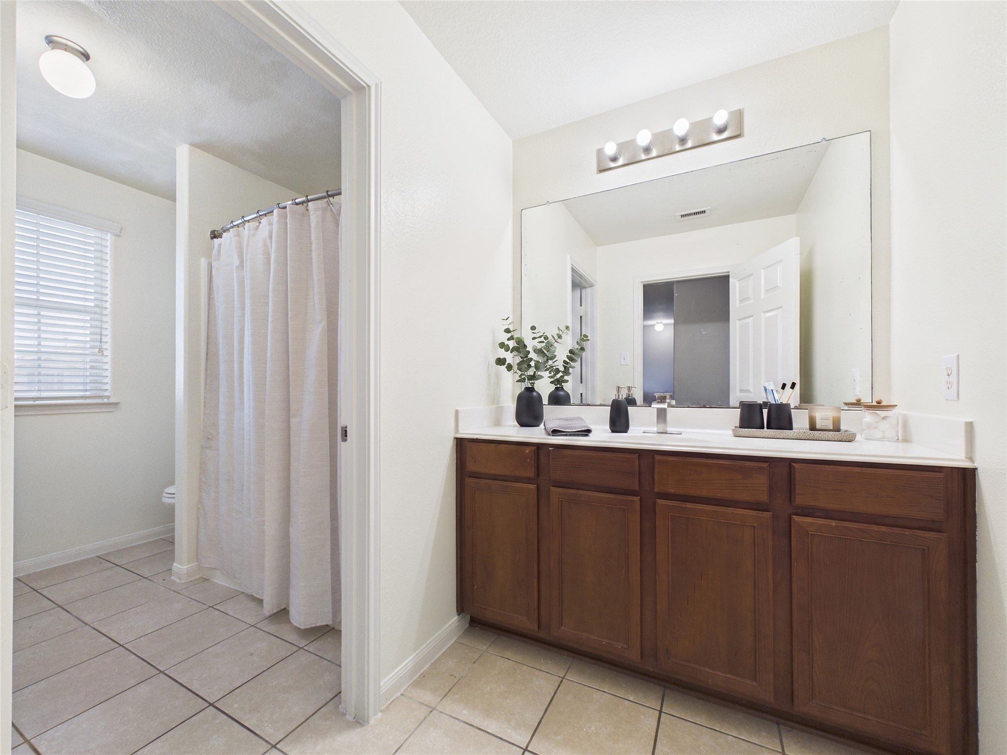 911 Marigold Road Baytown, TX 77521 - Photo 26 of 33 Spacious bathroom with elegant dual-sink vanity, large mirror, and a separate shower area, offering a bright and functional design.