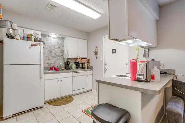 a kitchen with white cabinets and white appliances