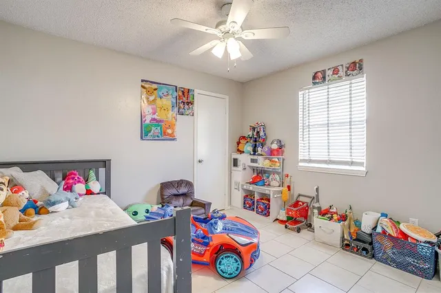 a bedroom with furniture and a chandelier fan