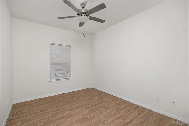 an empty room with a empty space and a ceiling fan