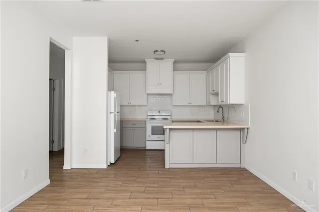 a kitchen with white cabinets and white appliances