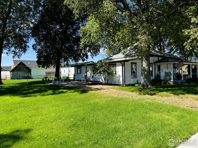 a view of a backyard with table and chairs under an umbrella