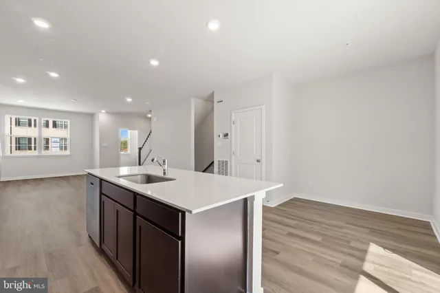 a view of a kitchen with stainless steel appliances granite countertop a stove top oven a sink and dishwasher