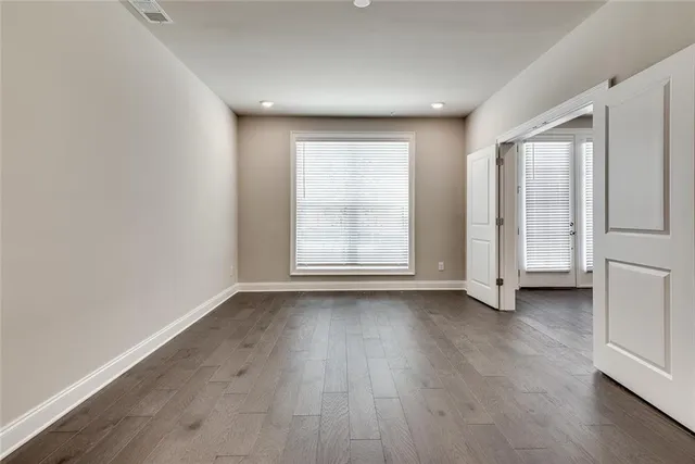 an empty room with wooden floor and window