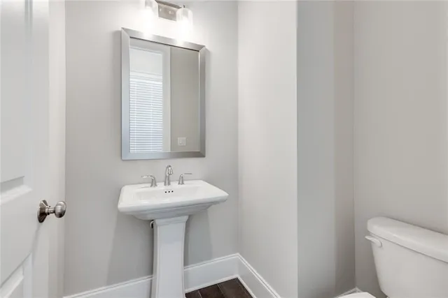 a bathroom with a sink toilet and a mirror