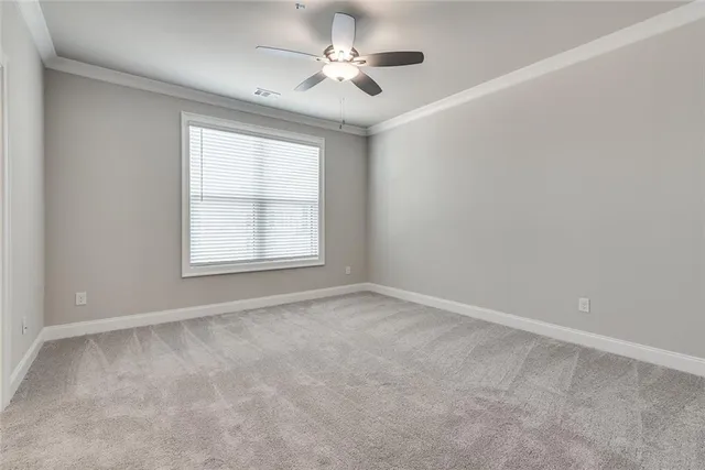 an empty room with windows and fan
