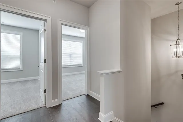 an empty room with wooden floor closet and windows
