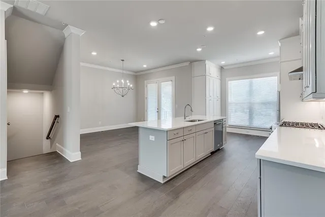 a large white room with kitchen island a sink wooden floor and view living room
