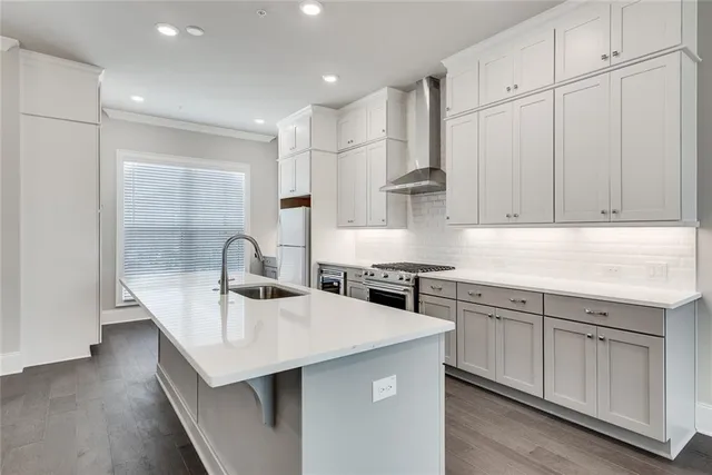 a kitchen with kitchen island granite countertop a sink a stove and cabinets