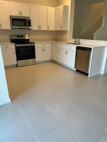 a kitchen with kitchen island a refrigerator sink and cabinets