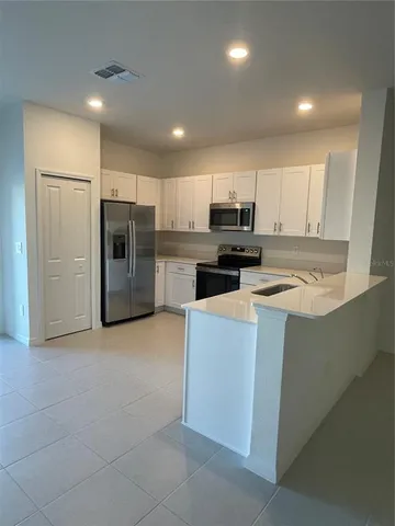 a kitchen with kitchen island a refrigerator a stove a microwave and cabinets