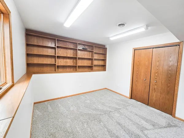 an empty room with windows and fan