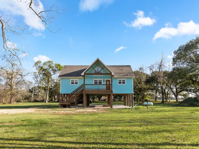 a front view of a house with a big yard and potted plants